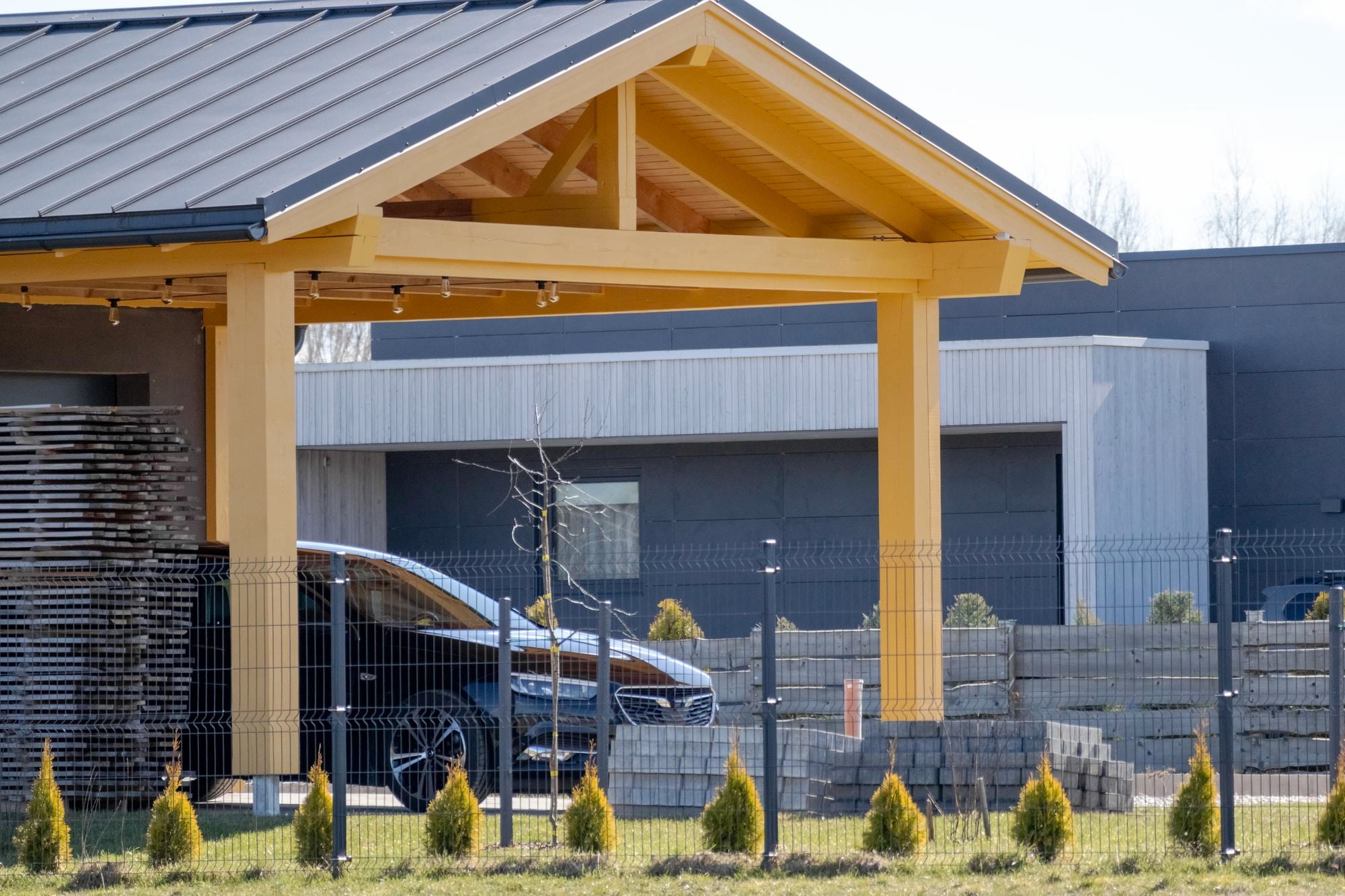 Parking couvert en bois attenant à une maison alliant fonctionnalité et esthétique naturelle
